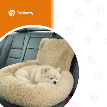 Kleine witte hond slaapt opgerold in het beige autobed op de achterbank