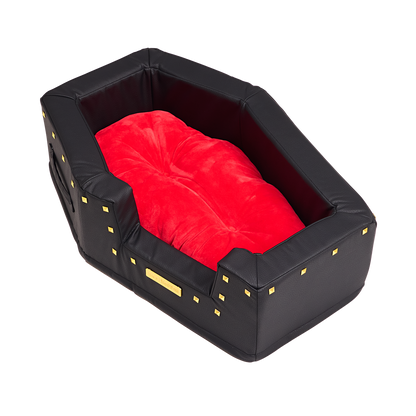 Lege hondenmand van boven schuin gezien met zacht rood kussen en goudkleurige studs