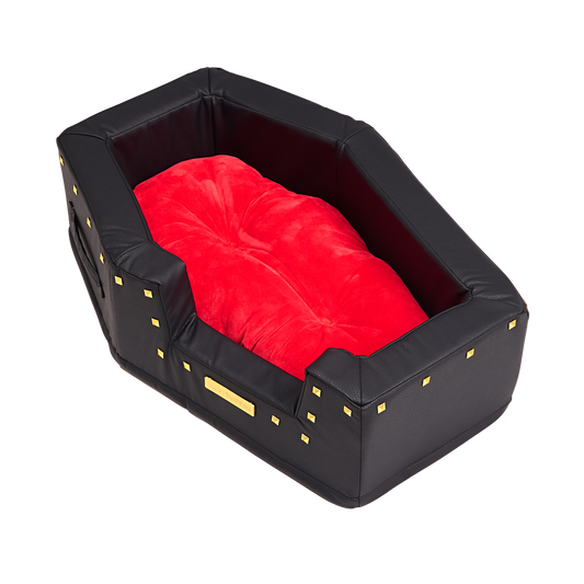 Lege hondenmand van boven schuin gezien met zacht rood kussen en goudkleurige studs