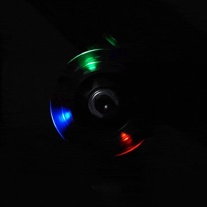 Close-up van een draaiend wieltje met rode, groene en blauwe ledlichtjes in het donker