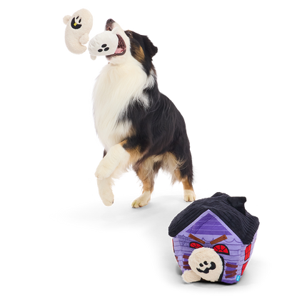 Springende hond vangt pluche spookje, snuffelspeelgoed met spookje op de grond