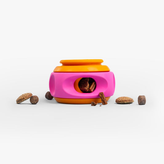 Roze en oranje snuffelspeeltje van natuurrubber met hondensnoepjes eromheen