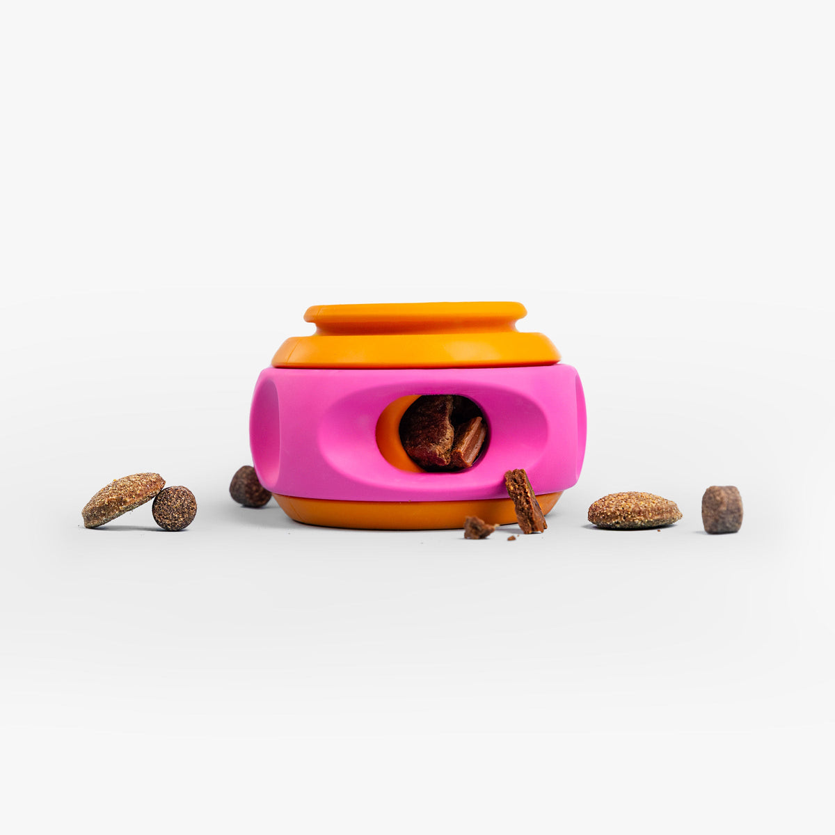 Roze met oranje draaiende snackpuzzel voor honden met snoepjes eromheen