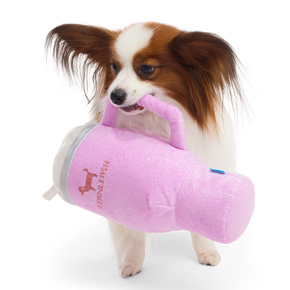 Papillon draagt de roze glitterbeker aan het handvat in zijn bek