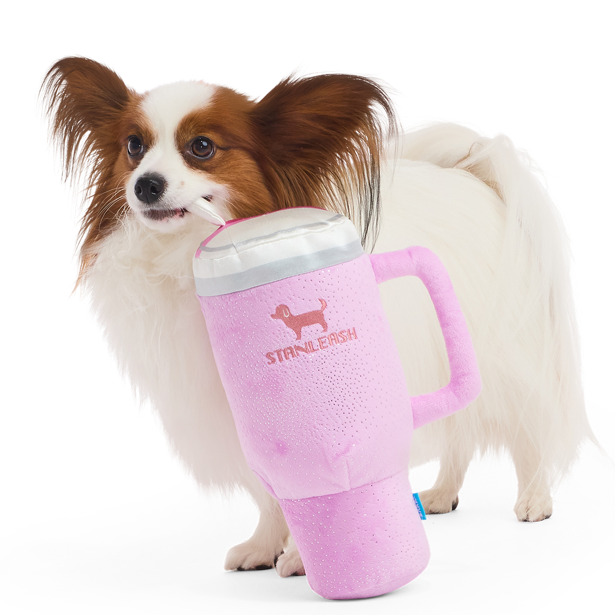 Roze pluche hondenknuffel in de vorm van een drinkbeker naast een papillon