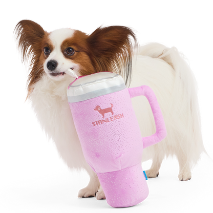 Roze pluche hondenknuffel in de vorm van een drinkbeker naast een papillon