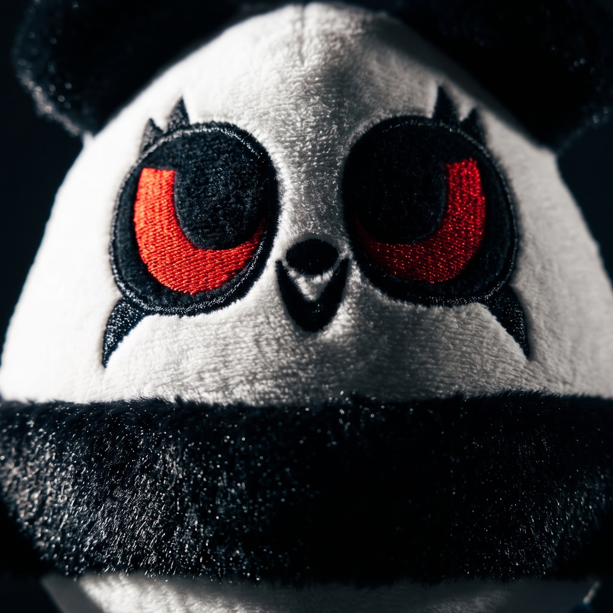 Close-up van het pandagezicht met rode geborduurde ogen en zwarte pluchen band