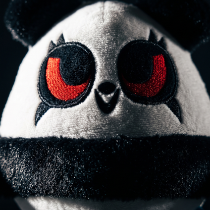 Close-up van het pandagezicht met rode geborduurde ogen en zwarte pluchen band