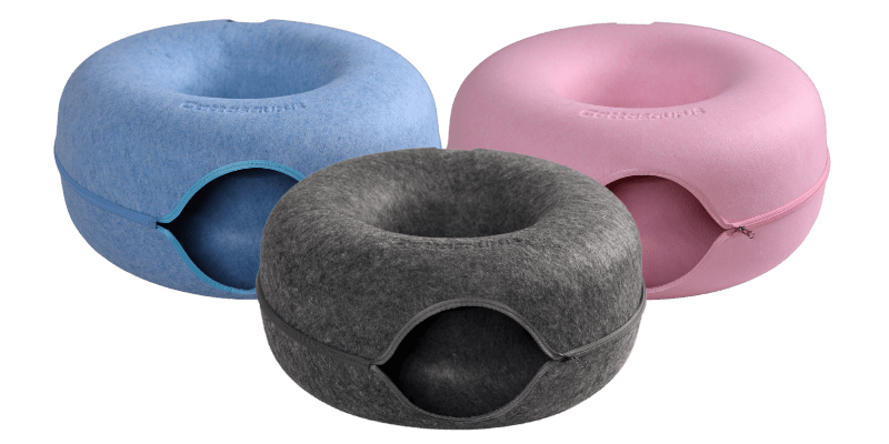 Donkergrijze kattengrot vooraan, blauw en roze op de achtergrond