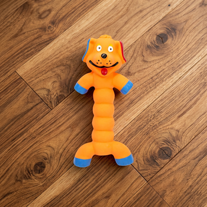 Oranje hondje met lang geribbeld lijf plat op een houten vloer