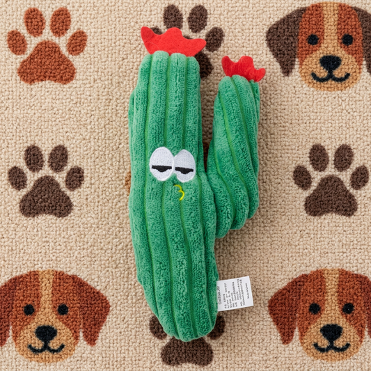 Donkergroene pluche cactus met rode bloempjes en geborduurde oogjes op pootjesmat