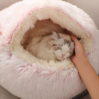 Hand aait een slapende kat in de opening van de roze kattenmand